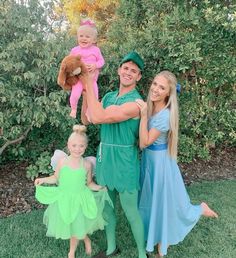 a man and two women are posing for a photo with their children in the grass