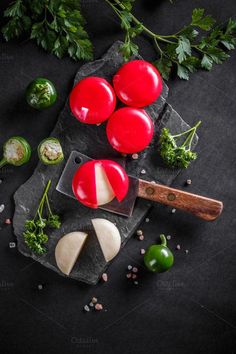 tomatoes, cheese and parsley on a black slate board with green pepper sprigs