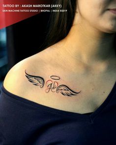 a woman with a tattoo on her chest and wings above her shoulder, behind her ear