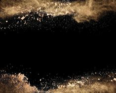 a black and gold background with some white powder in the air on top of it