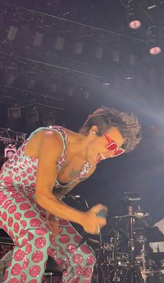 a woman with red lipstick on her face performing at a concert