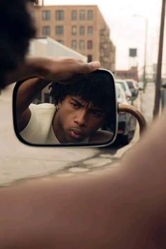 a man looking at himself in the side view mirror