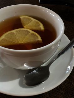 a cup of tea with lemon slices in it