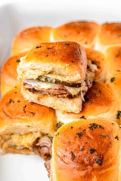 several sliders stacked on top of each other with meat and cheese in the middle