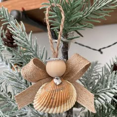 an ornament hanging from a christmas tree with pine cones and twine wrapped around it