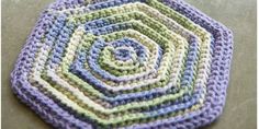 a crocheted potholder with a spiral design on it's side, sitting on a table