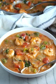 two bowls filled with shrimp and vegetable soup