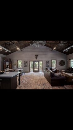 a large open living room with wood floors and vaulted ceilings, is pictured in this image