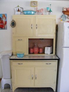 an old fashioned kitchen with white appliances and pictures on the wall