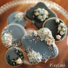 four decorated cookies sitting on top of a glass plate