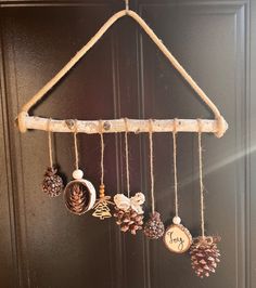 a door hanger with pine cones and ornaments hanging from it