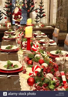 a table set for christmas dinner with red and white decorations