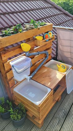 an outdoor potting station made out of pallets and wooden boards with plastic containers on top