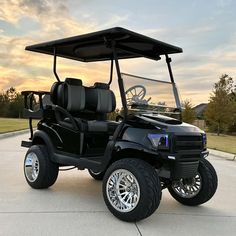 a black golf cart parked on top of a driveway