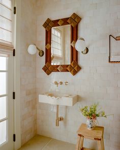 a bathroom with a sink, mirror and stool