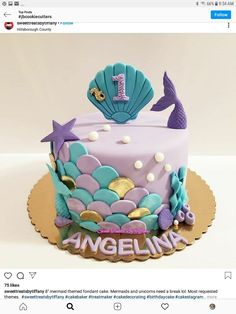 a birthday cake decorated with an image of a mermaid on the top and under it