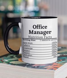 a black and white coffee mug sitting on top of a book