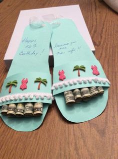 an open pair of flip flops decorated with money and palm trees on the inside