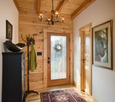 an entryway with wood paneling and a rug on the floor next to it