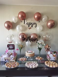 a table topped with lots of desserts and balloons