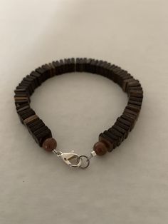 Men's 8-inch bracelet has small square beads that look wooden but are acrylic. There are 2 round beads at each end and a lobster claw clasp closure. All the men's bracelets are true-to-size. Brown Wooden Bracelets With Round Beads, Brown Wooden Beaded Bracelets With 8mm Beads, Brown Wooden Beads For Bracelets, Brown Wooden Beaded Bracelet, Brown Wooden Bracelet With 8mm Beads, Brown Wooden Beaded Bracelets With Round Beads, Brown Wood Beaded Bracelets With Round Beads, Brown Wooden Beaded Bracelets, Brown Wood Beaded Bracelets