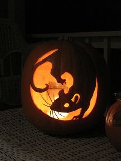 a cat carved into a pumpkin with its head in the shape of a mouse on it