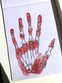 a piece of paper with a drawing of a hand on it and red ink in the middle