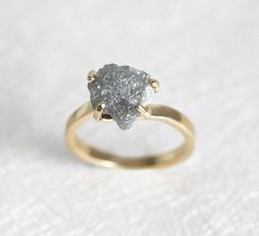 a gold ring with a rough diamond on it