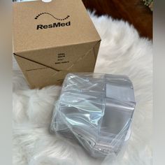 the box is sitting on top of the white fur covered floor next to it's packaging