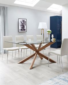 a glass dining table with white chairs around it