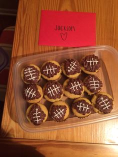 a plastic container filled with cupcakes covered in frosting next to a red note