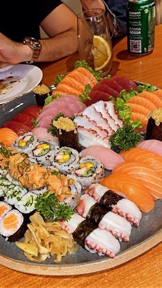 an assortment of sushi on a platter at a restaurant