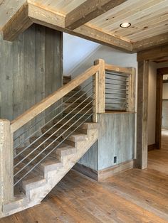 an empty room with wooden floors and stairs