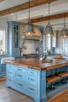 a large kitchen with blue cabinets and wooden counter tops, an island in the middle