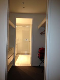 an open door leading into a small room with white walls and carpeted flooring