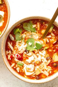 two bowls filled with soup and vegetables on top of a white countertop next to each other