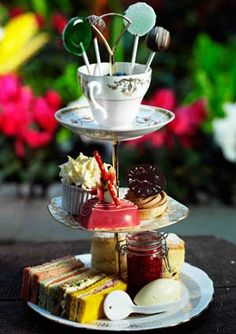 three tiered tray with cupcakes, cookies and other desserts on it