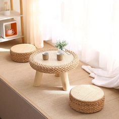 two wicker tables sitting on top of a carpeted floor next to a window