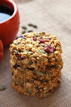 three granola cookies stacked on top of each other with cranberries and pumpkin seeds