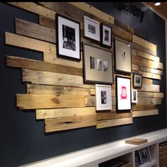 a wall made out of wooden planks with pictures hanging on the side and bookshelves below