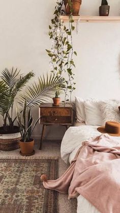 a bedroom with lots of plants on the wall and rugs in front of the bed