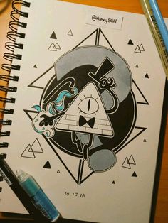 a spiral notebook with an image of a skull and triangle on the cover next to a pencil