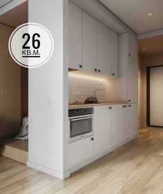 a kitchen with white cabinets and wood flooring next to an open door on the wall