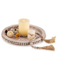 a white candle sitting on top of a wooden tray