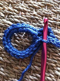 a crochet hook with blue yarn on it and a red handled knitting needle