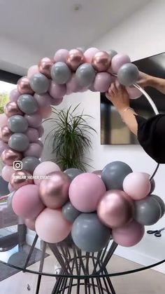 a woman is holding balloons in the shape of a letter o on top of a table