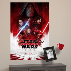 a star wars movie poster hangs on the wall next to a dresser and coffee cup