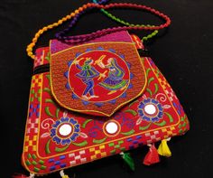 This Is Indian Red And Multi Colour Handmade Embroidered Ethnic Rajasthani Style Floral Design Fabric Tassels Mirror Work Design Bag For Occasion Wedding Gift Embroidered Bag Uses With Designer Saree ,Wedding Gift ,Return Gift , Special Occasion . Length 23 CM Width   23 CM                                                                                                                                                                                                                     + This  Purse is Used For - Wedding dresses  Designer Sarees .                              +This Purse is Used For -Clutches, Hand Bags .                                                         +This  Purse Used For- Handbags , Special Occasion ,Return Gift . Festive Celebration Bags With Tassels, Traditional Festive Bags With Tassels, Traditional Red Bags With Motifs, Red Bags With Tassels For Festival, Traditional Red Bags For Festival, Traditional Red Festival Bags, Red Embroidered Festival Bag, Mirror Work Design, Tassels Design