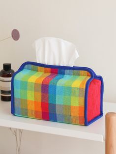 a multicolored plaid tissue dispenser on a white table