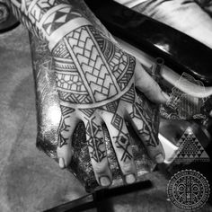 a person's hand with tattoos on it